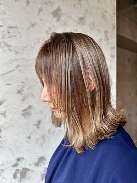 ベージュ系カラーのロングヘアに光が当たる後ろ姿